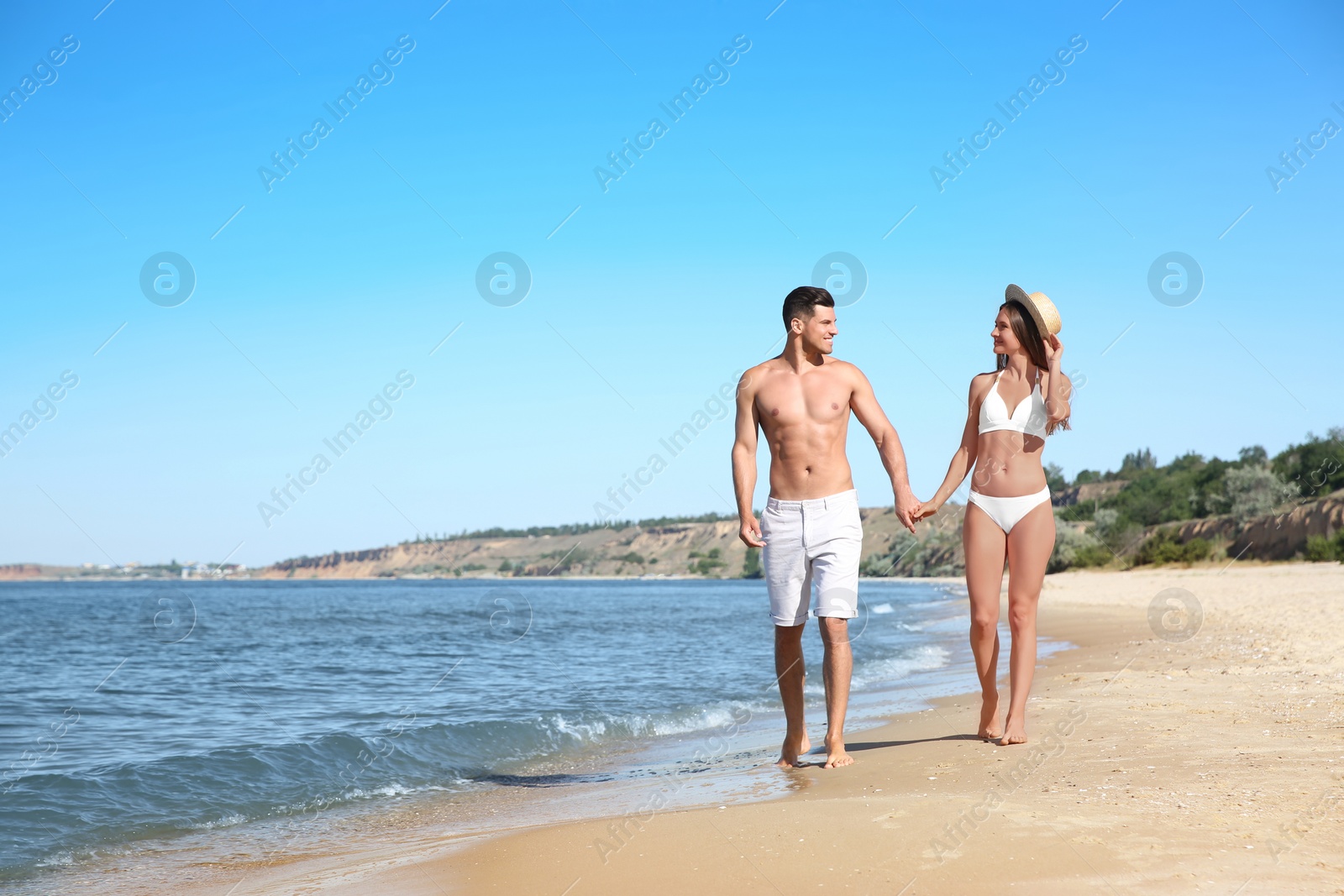 Photo of Woman in bikini and her boyfriend on beach, space for text. Happy couple