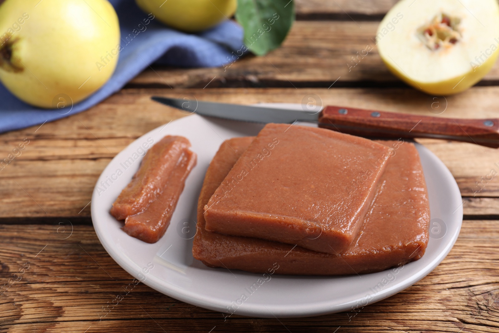 Photo of Plate with quince paste on wooden table