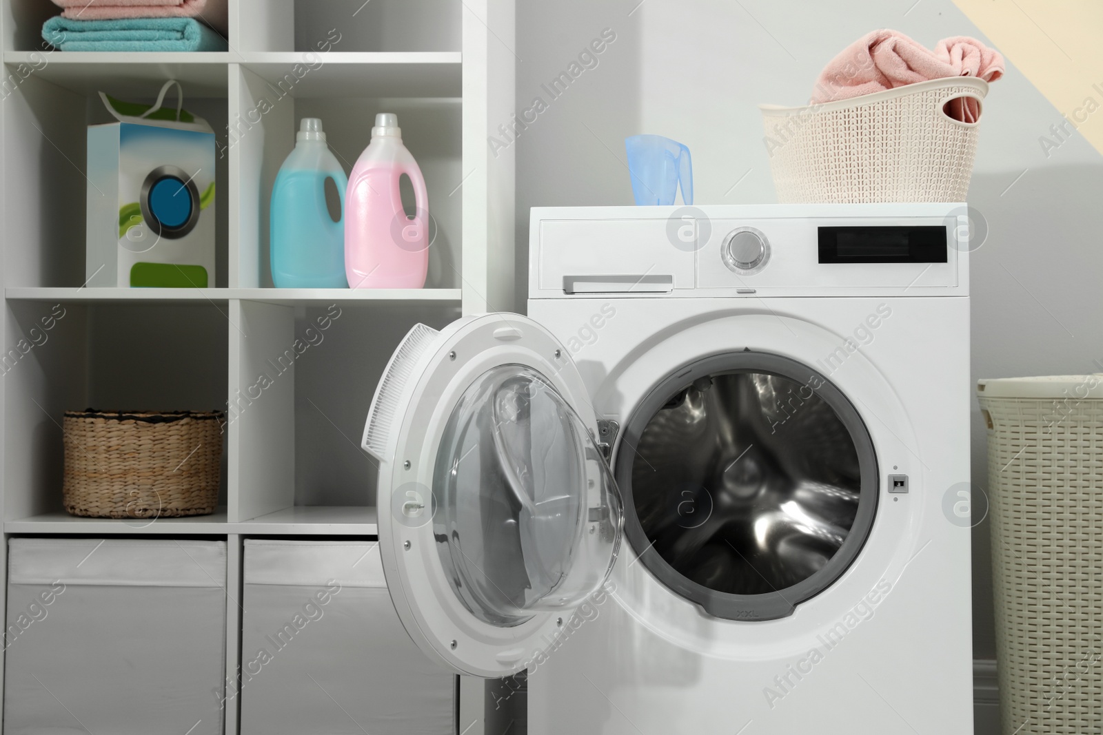 Photo of Modern washing machine in laundry room interior