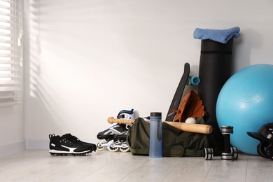 Photo of Many different sports equipment near wall indoors