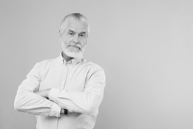 Portrait of handsome senior man on light background, space for text. Black and white effect