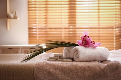 Beautiful spa accessories on massage table in room