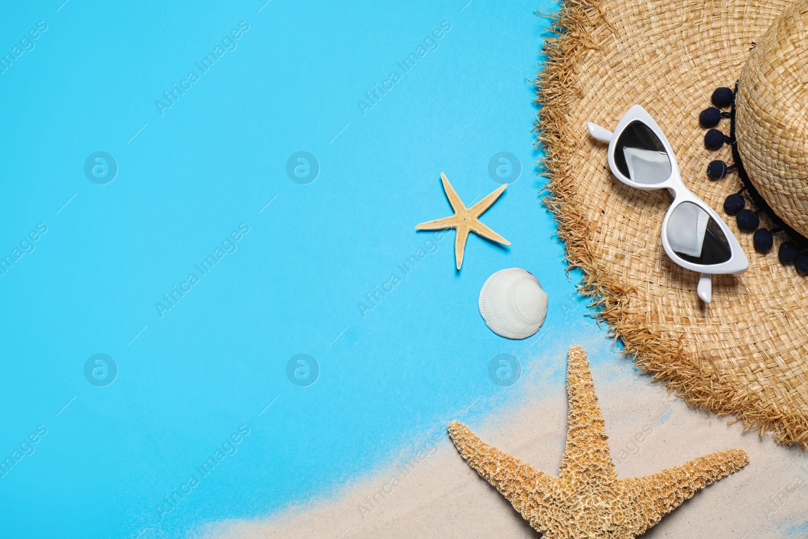 Photo of Flat lay composition with stylish beach accessories on light blue background, space for text