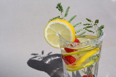 Delicious refreshing lemonade with raspberries on light gray rattan surface, closeup. Space for text