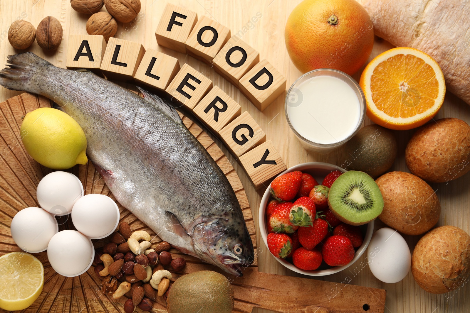 Image of Food allergy. Different fresh products and cubes on wooden table, flat lay