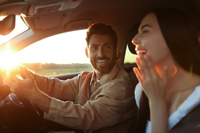 Photo of Happy couple enjoying trip together by car, selective focus