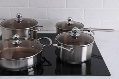 Photo of Set of new clean cookware on cooktop in kitchen