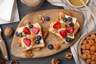 Photo of Tasty brie cheese sandwiches on grey wooden table, flat lay