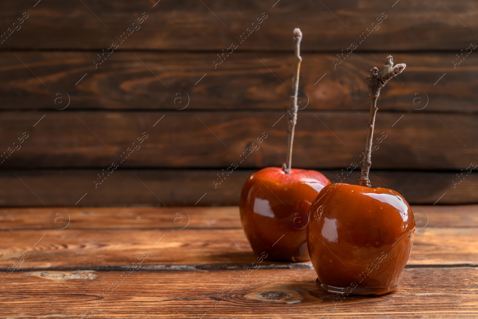 Photo of Delicious red caramel apples on table