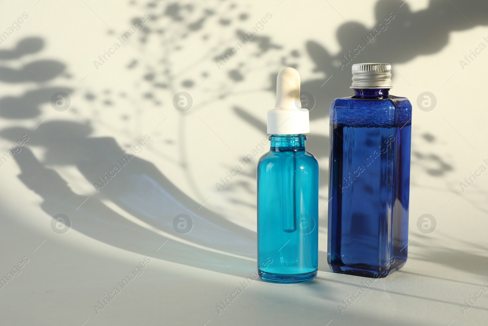 Photo of Bottles of cosmetic products on white background. Space for text