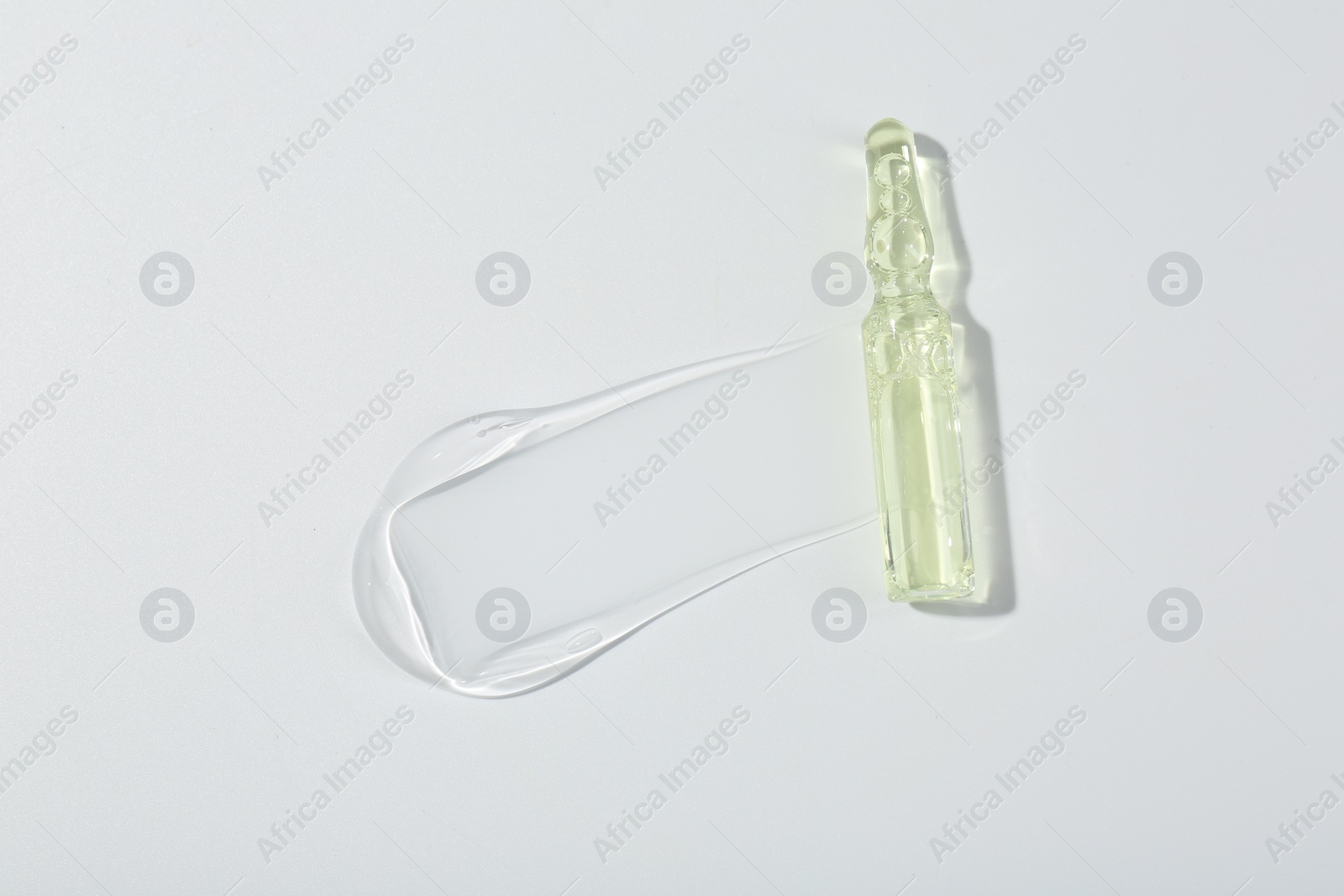 Photo of Skincare ampoule on white surface with gel, top view