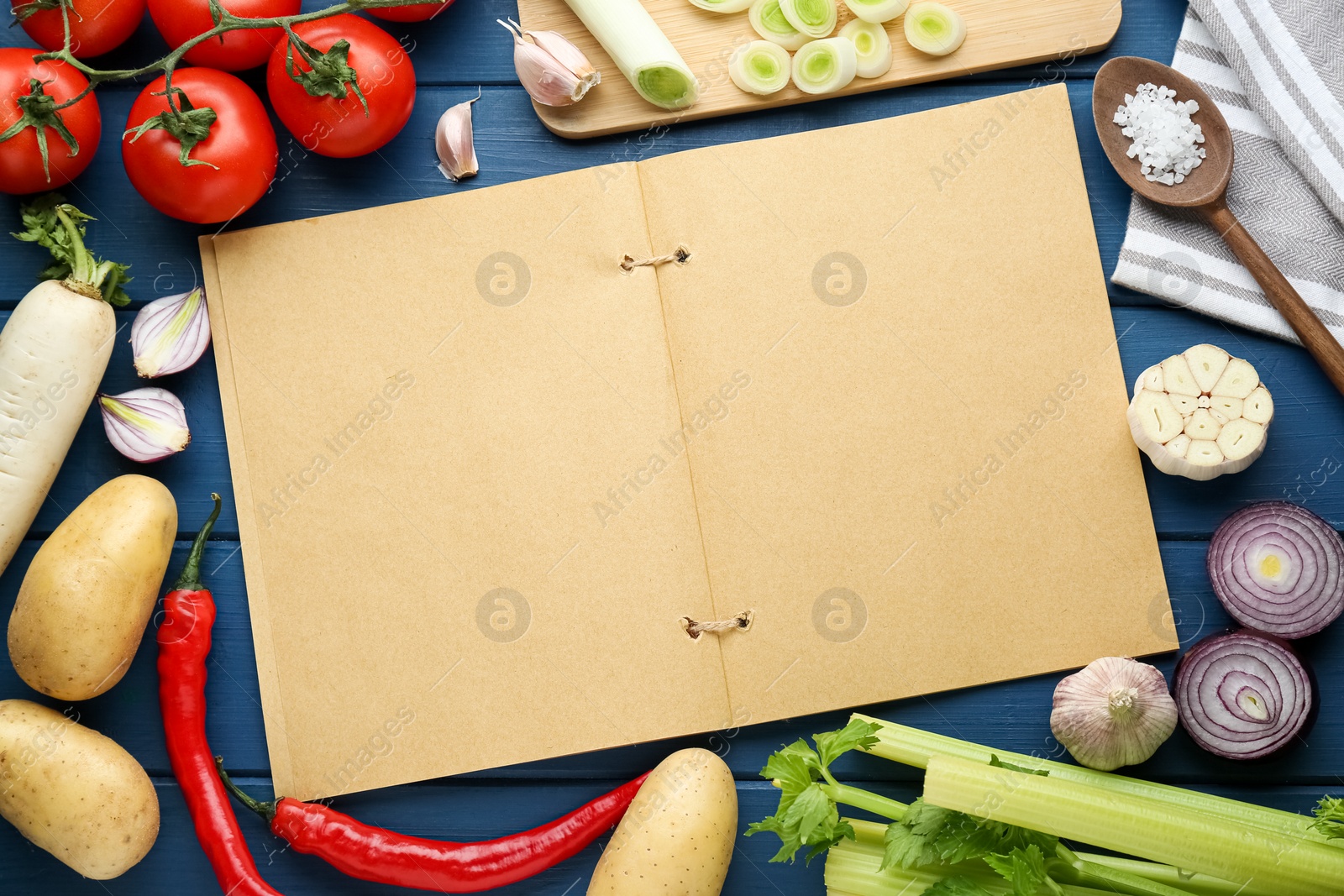 Photo of Blank recipe book surrounded by different ingredients on blue wooden table, flat lay. Space for text