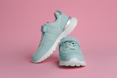Pair of stylish sneakers on pink background