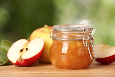 Delicious apple jam and fresh fruits on wooden table