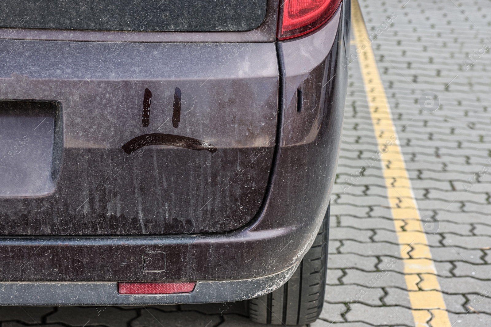 Photo of Sad smiley on dirty car outdoors, closeup