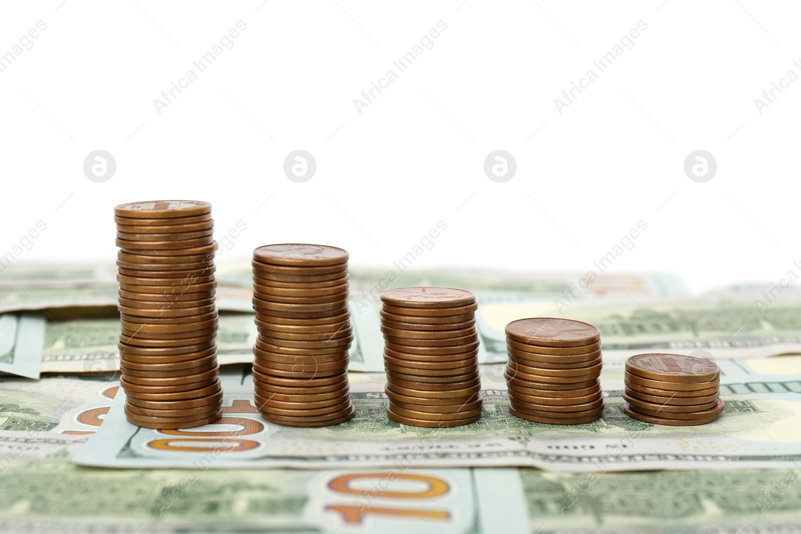 Photo of Stacks of metal coins on dollar banknotes against white background