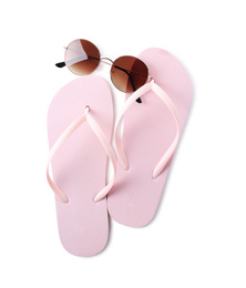 Flip flops and sunglasses on white background, top view. Beach objects