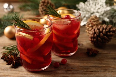 Photo of Delicious punch drink with cranberries and orange on wooden table