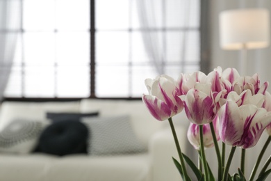 Blurred view of modern room interior, focus on fresh flowers