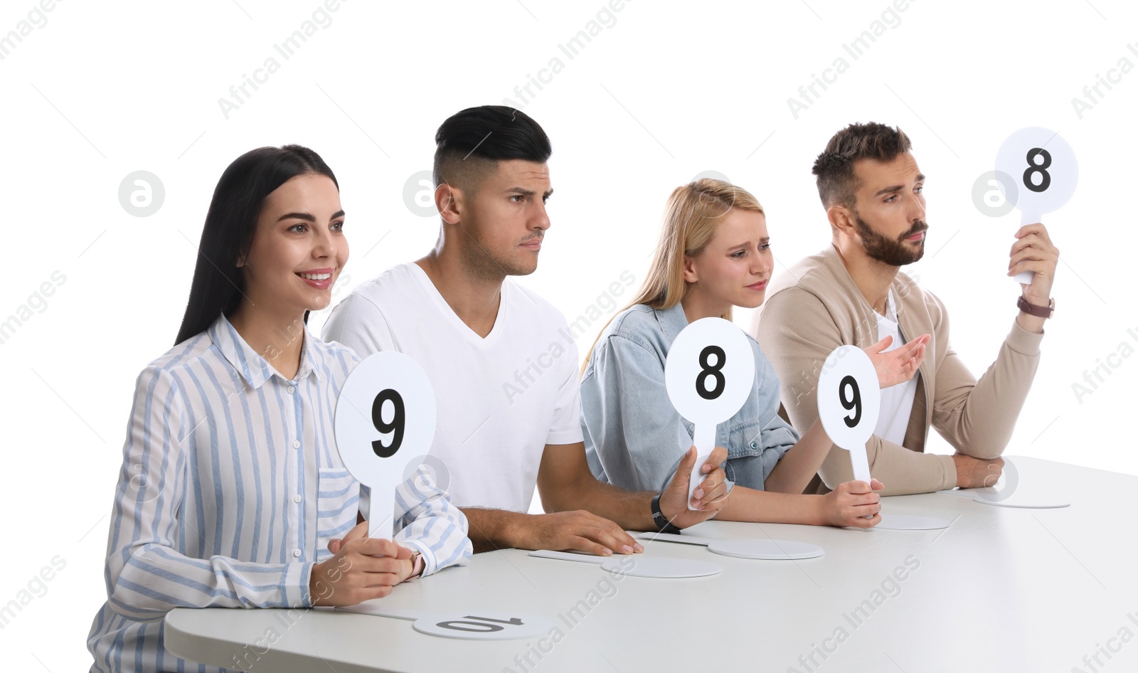 Photo of Panel of judges holding different score signs at table on white background