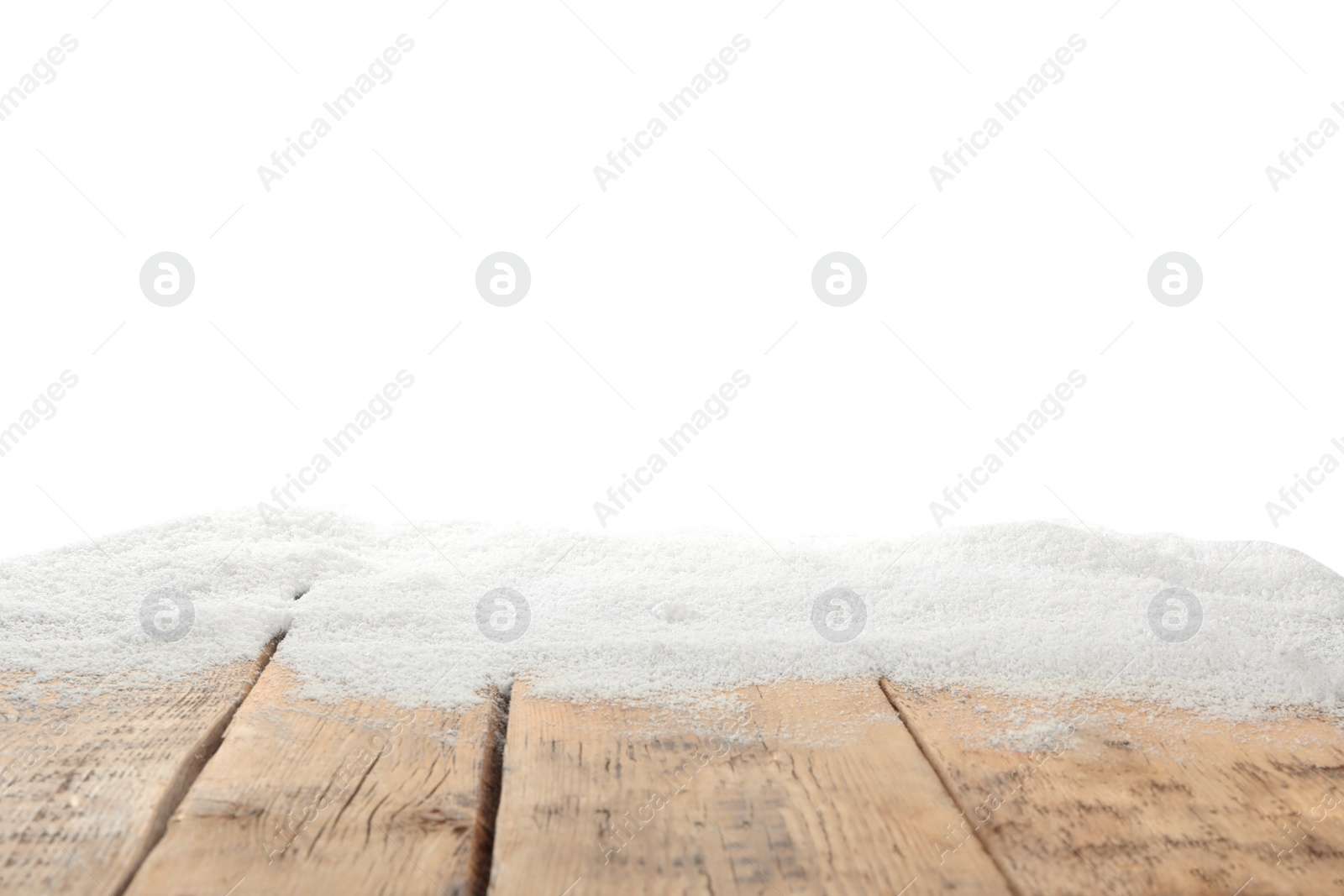 Photo of Artificial snow on wooden table against white background. Christmas decor