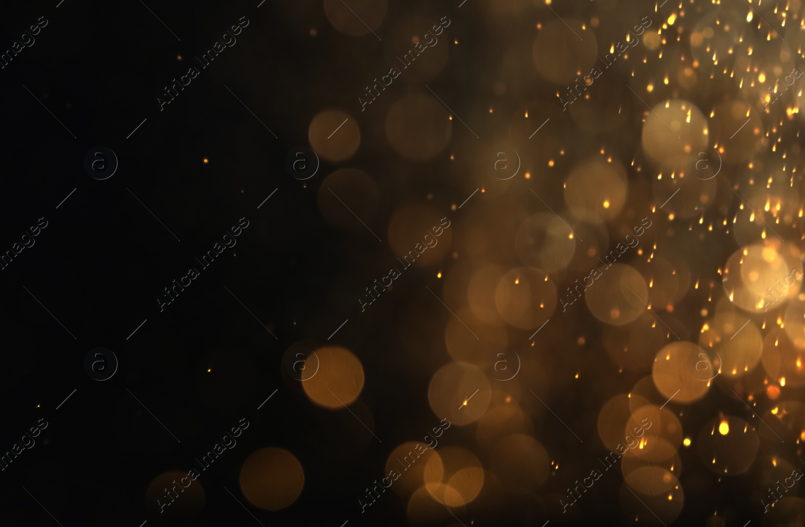 Photo of Blurred view of golden lights on black background. Bokeh effect