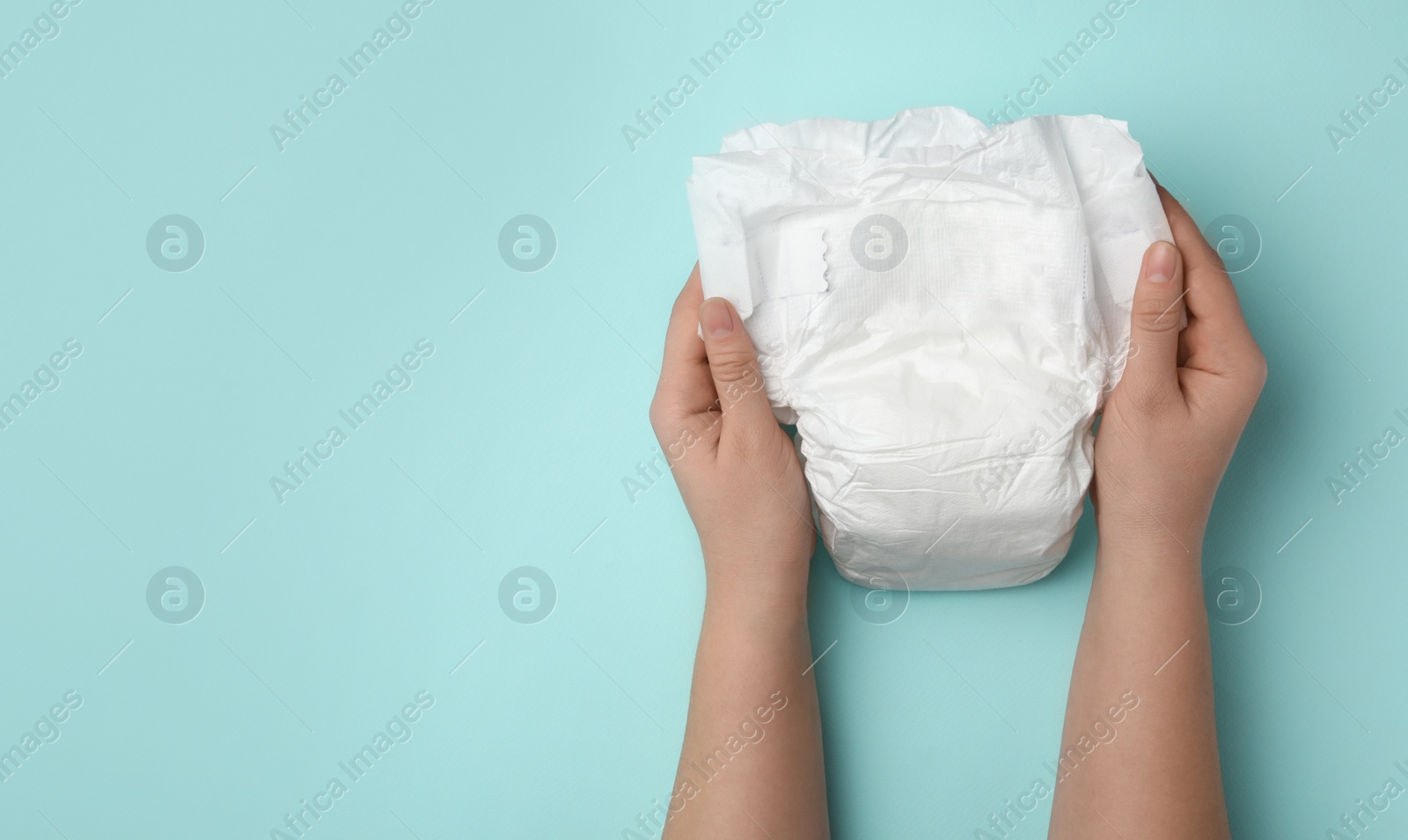 Photo of Woman with diaper on turquoise background, closeup. Space for text