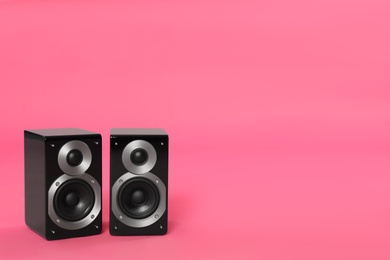 Photo of Modern powerful audio speakers on pink background, space for text