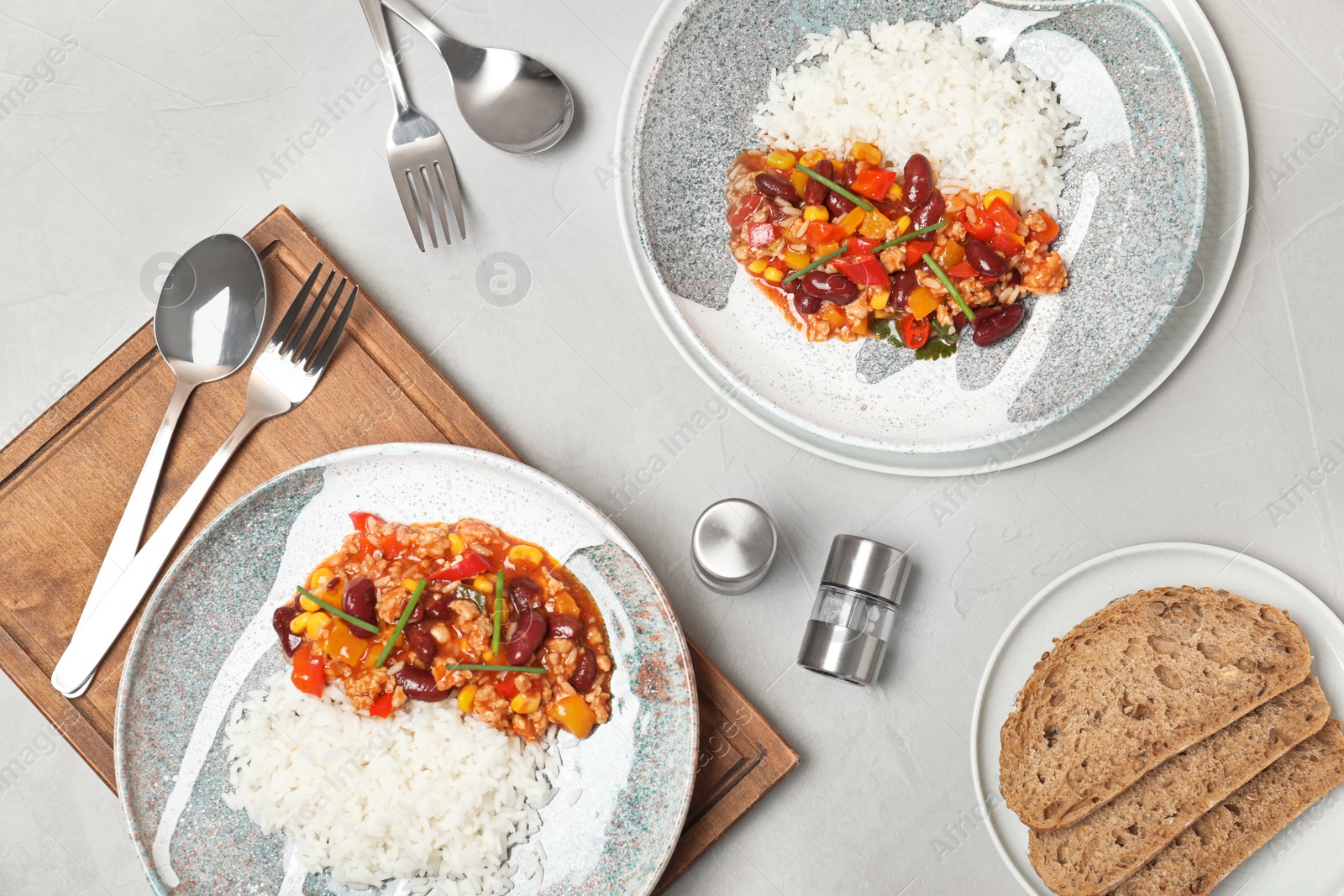 Photo of Chili con carne served with rice on gray table, flat lay