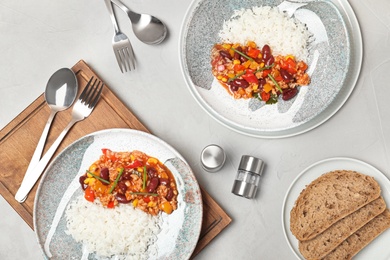 Photo of Chili con carne served with rice on gray table, flat lay