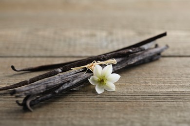 Vanilla pods and flower on wooden table, closeup