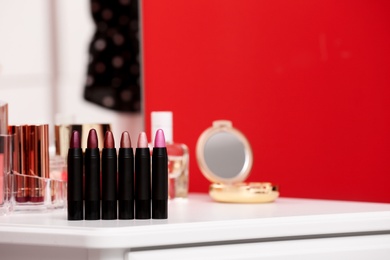 Different lipsticks on dressing table. Space for text