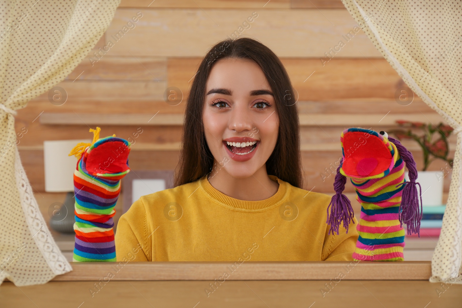 Photo of Young woman performing puppet show at home