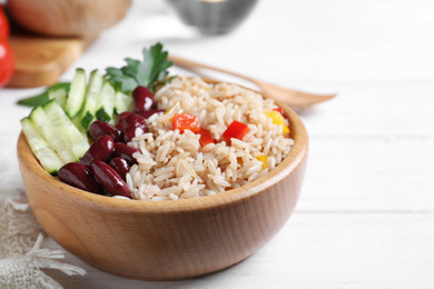 Photo of Delicious rice with beans served on white wooden table, closeup