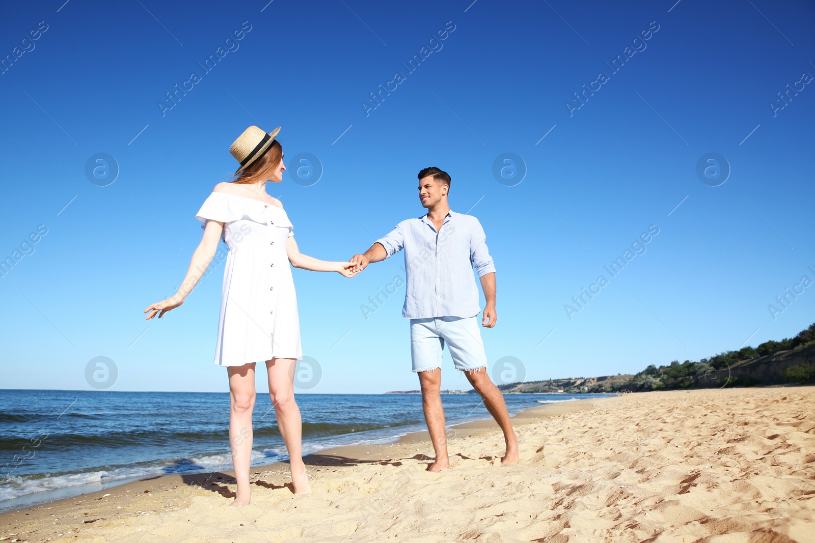 Photo of Lovely couple walking together on sandy beach