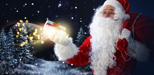 Image of Santa Claus with gift and red sack in winter forest. Christmas magic. Banner design