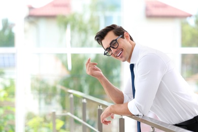 Photo of Handsome young man in stylish clothes with glasses indoors. Space for text