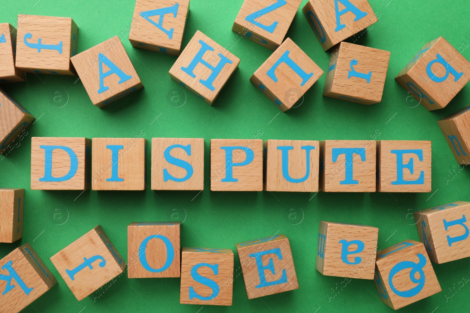 Photo of Cubes with word Dispute on green background, flat lay