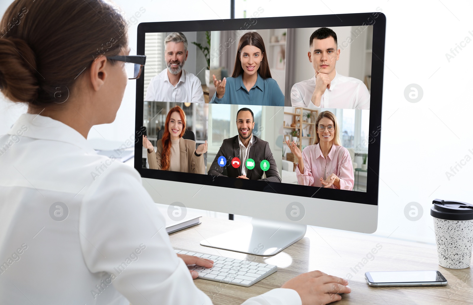 Image of Woman having video chat with coworkers at office