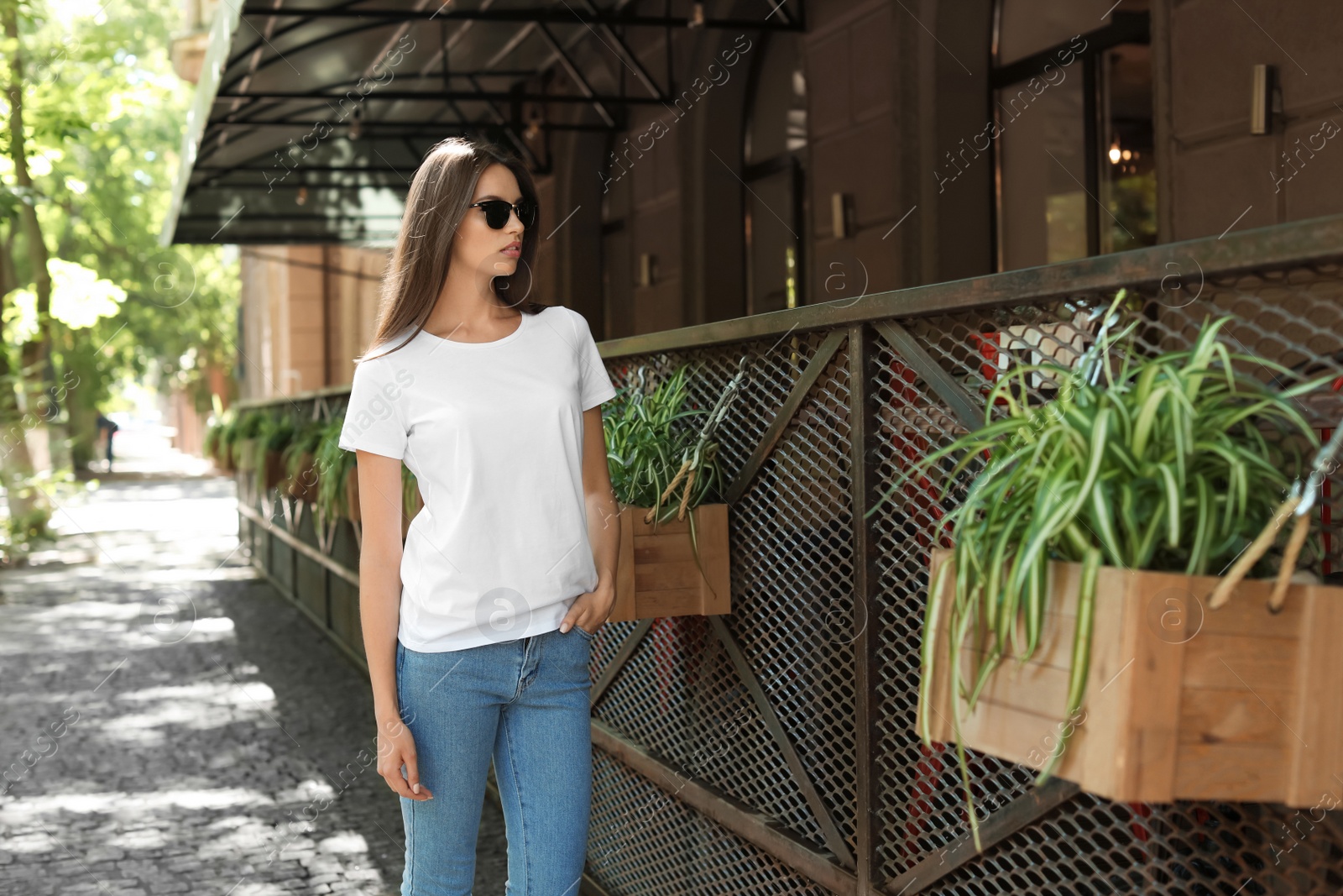 Photo of Young woman wearing white t-shirt on street