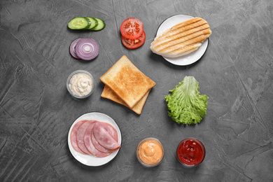 Photo of Fresh ingredients for tasty sandwich on grey background, flat lay