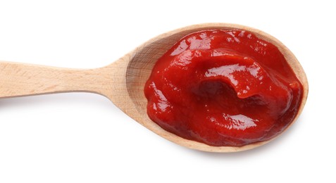 Photo of Tasty ketchup in wooden spoon isolated on white, top view