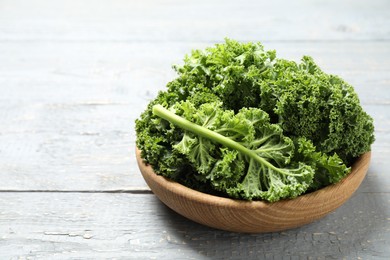 Photo of Fresh kale leaves on light grey wooden table