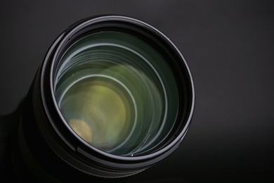 Photo of Modern camera lens on black background, closeup