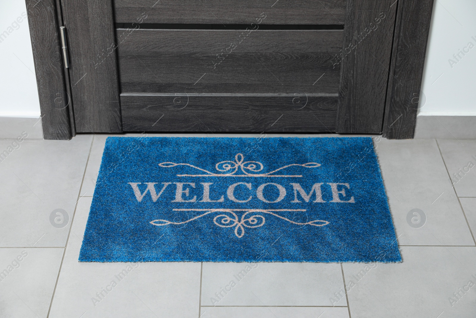 Photo of Beautiful doormat with word Welcome on floor near entrance