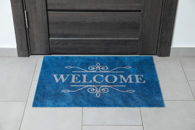 Photo of Beautiful doormat with word Welcome on floor near entrance