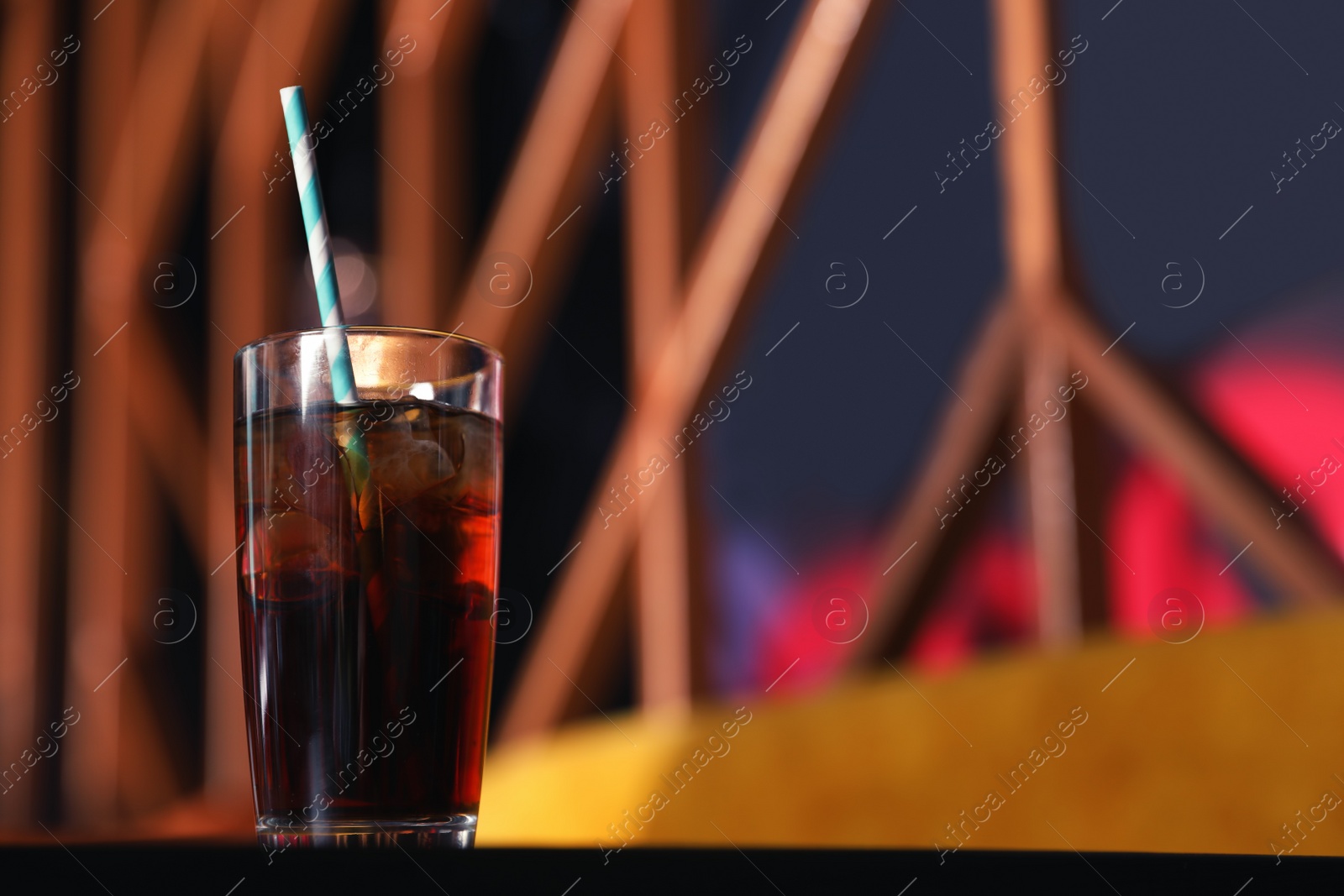 Photo of Glass of refreshing cola with ice on table indoors. Space for text