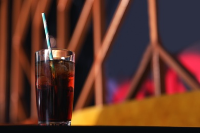 Glass of refreshing cola with ice on table indoors. Space for text