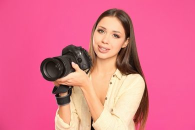 Photo of Professional photographer working on pink background in studio