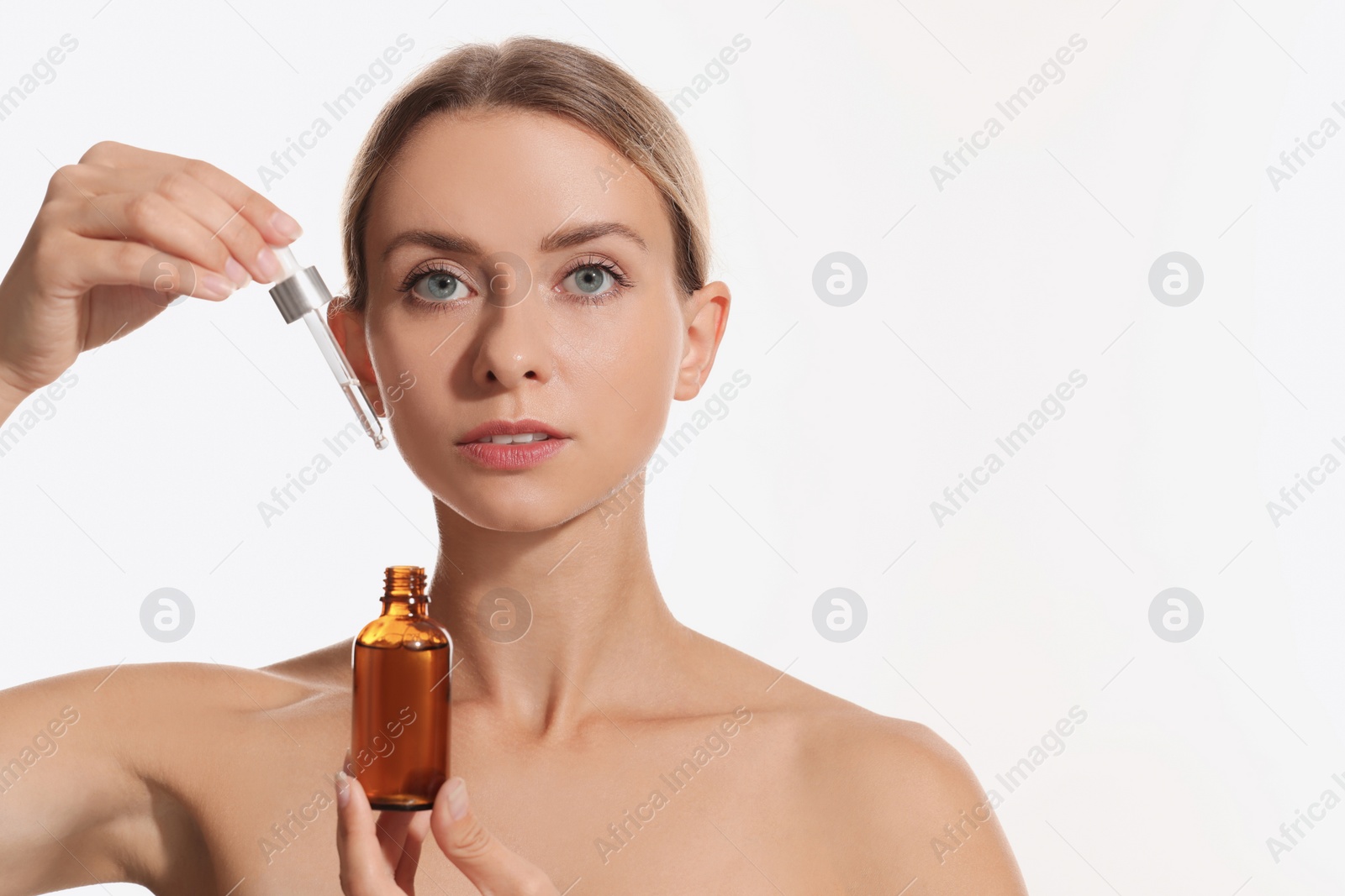 Photo of Beautiful woman with cosmetic serum in her hands on white background, space for text